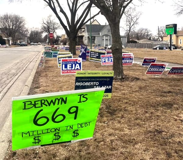 A street corner in Berwyn, Illinois, displaying numerous alderman campaign signs arranged on a grassy area near a sidewalk. Prominent is a sign that reads "BERWYN IS 669 MILLION IN DEBT"