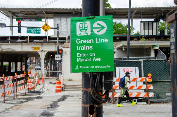 A bright green sign that reads "Green Line trains Enter on Mason Ave" is shown outside the CTA’s Green Line Austin station direct riders to the temporary entrance.