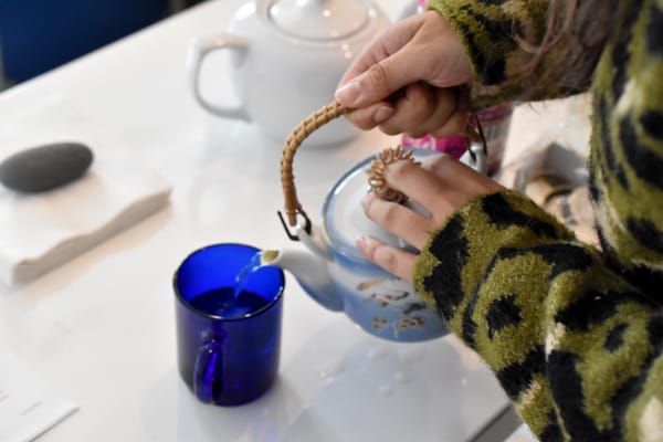 Mijares pouring rose tea into a cup as guests arrive. | NaBeela Washington/15 West